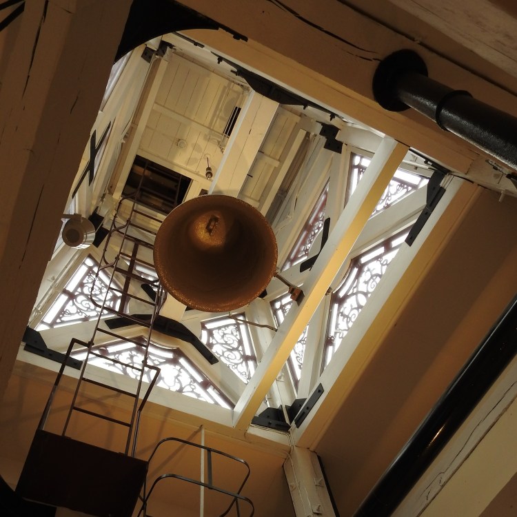 Underneath the cast iron clock tower and bell